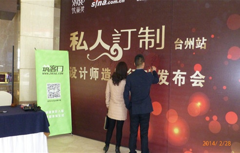 图为：设计师在台州站活动宣传板上签名留念