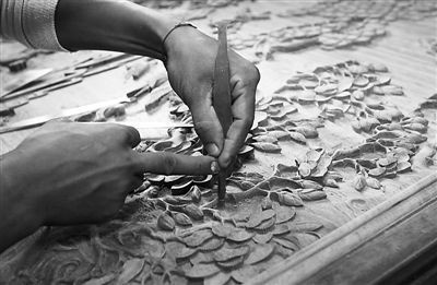 云南德宏州瑞丽市滇野红木文化产业园，技术工人正在进行红木家具的雕刻制作。