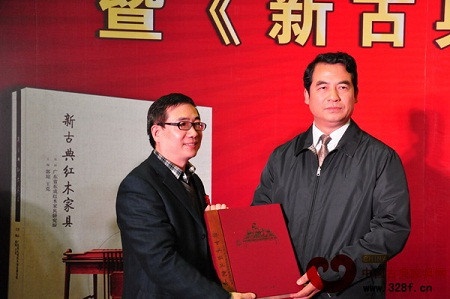 中国林业产业联合会秘书长、中国林产工业协会执行会长王满(右)向华南农业大学林学院代表赠书