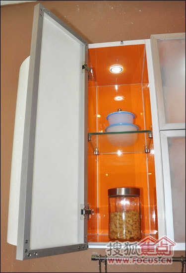 吊柜上的窄边铝框边门映衬橙色的柜体