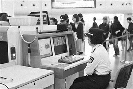 上图：轨交站安检人员正在监视安检屏幕。
