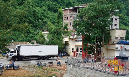 刚刚通过关卡的一辆越南货车进入中国(画面右侧为两国界碑)