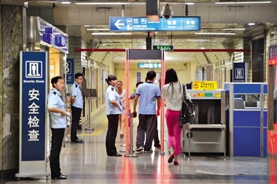 昨日下午，地铁1号线东单站，乘客经过安检门后进入车站。 新京报记者 吴江 摄
