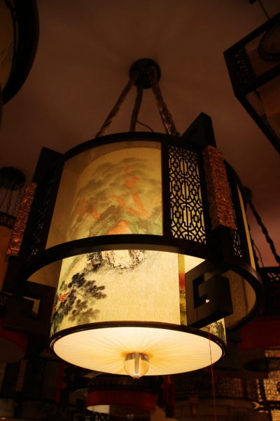 万隆汇洋丽都中式馆的中式吊灯，刻着金色祥云，手绘山水画，如同艺术品（图四）