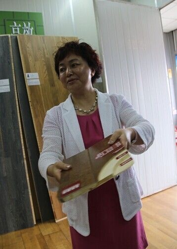 圣象康逸事业部总经理朱玲英为媒体们展示圣象三层实木地板的先进工艺
