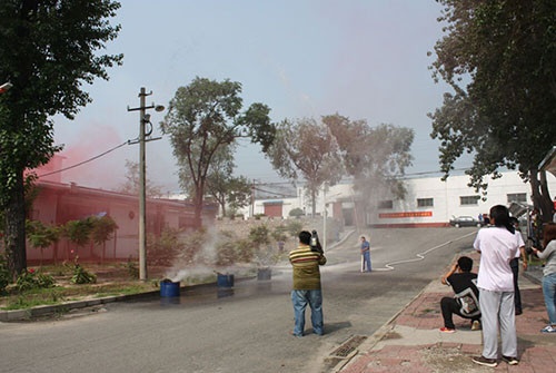 图为：房山消防中队代表为学习人员讲解消防栓水带的正确使用与整理