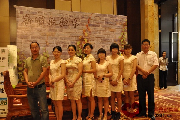 唐明居红木总经理胡高华（右一）与销售人员以饱满的热情迎接每一位顾客