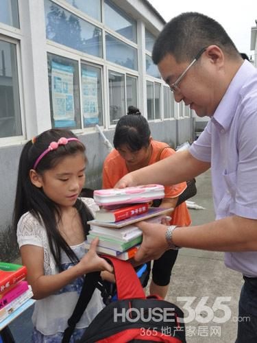 马可波罗瓷砖慈善基金会秘书长李军林亲自把爱心礼物交到孩子手上。