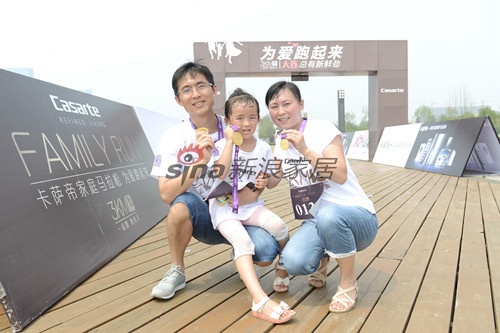 在大连海边木栈道上，父母带着女儿一家三口共同完成3KM，收获爱的奖牌