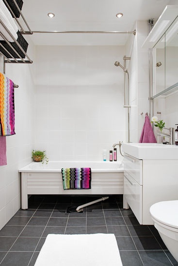 卫生间同样采用白色墙面和家居搭配黑色地板，干净清爽。洗手台下的两层柜子便于收纳。