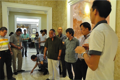 芒果瓷砖副总经理兼产品总监徐华军(右一)带领嘉宾们参观庄园展厅