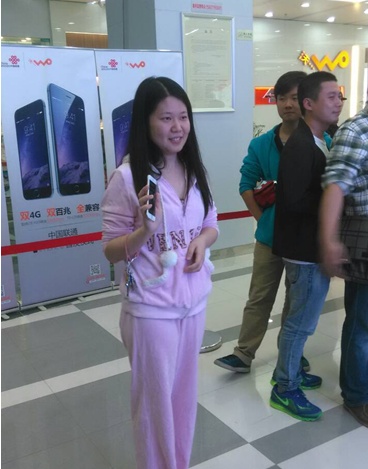 图为：湖北香港路联通厅首销，首个用户王小姐高兴领机