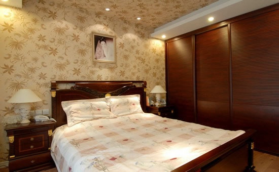 米黄暗花的壁纸配上红木的衣柜和床使整个卧室的感觉显得安静舒适
