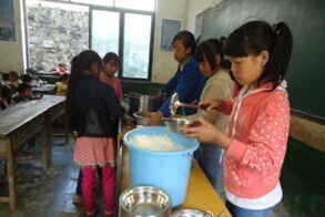 (图)孩子们帮助老师为同学们分配免费午餐