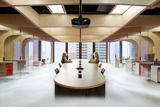 木材面板划分出了一个中央办公空间，以及周边一系列私人办公室