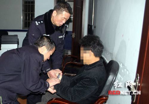 民警将陈某上铐准备将其送到看守所刑事拘留。