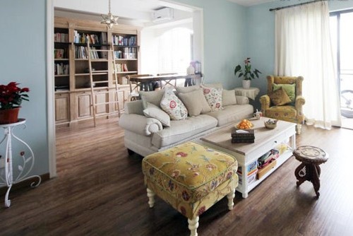 5木色地板、米色沙发和窗帘、浅蓝色背景墙形成柔和的撞色