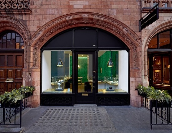 黛尔菲娜·德里崔兹品牌与现代主义的cabinet de curiosité,合作，于近期完成了伦敦的店面橱窗展示，这次展示的展品包含了德里崔兹的全系列作品，其中包括“穿孔”系列，以及专供该商店售卖的限量系列。伦敦店面位于蒙特街109号，整个店面有两层，使用面积共650平方英尺。 活跃在纽约和伦敦两地的建筑师 rafael de cárdenas 与delettrez品牌合作，营造了一处别具一格的空间，用浪漫的手法模仿了设计师自身对空间的敏感度，探索出材料与形状的更多可能性。多种各异的材料在设计中达到了和谐统一，磨砂材质和反光材质、工业材料和有机材料，甚至更加意外的金属和纹理材质的组合，正是这些反差极大的材质共同定义了独特的室内空间。室内墙面上排镶有绿色的镜面，给人一种超越实体墙面以外无限向外界扩张的错觉。在这样的虚幻环境之中，每件珠宝的影像成倍增加，且经过多重反射和放大，以一种超现实主义的风格呈现在顾客面前，使得顾客有一种置身于珠宝内部的奇妙感受。