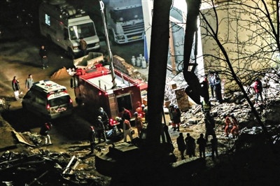 昨日凌晨4时许，朝阳区健博润彩家居城坍塌现场，两名被困工人的遗体被抬向救护车。 实习生 彭子洋 摄