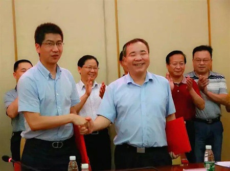 居然之家湖南分公司总经理顾月明先生（左）与湖南老爹实业科技开发股份有限公司董事长田儒斌先生（右）合影