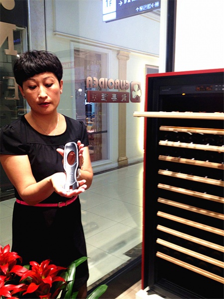 欧美佳店店长李英展示红酒储藏柜的固定凹槽