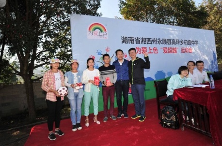 立邦中国区总裁钟中林（Eric Chung，右一）、陶氏涂料材料业务部亚太区总经理林育麟（右二）共同为孩子们送上礼物