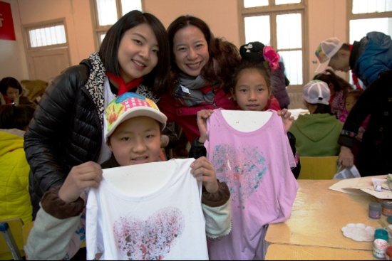 立邦「为爱上色」快乐美术课上，在志愿者美术老师的引导下，同学们在T恤上作画