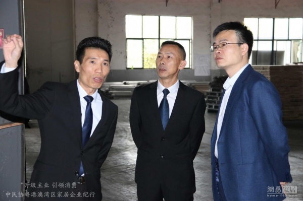 中国民协家居消费专委会媒体采访团参观柏尔车间，柏尔企划总监颜喜斌先生介绍柏尔实木地板。